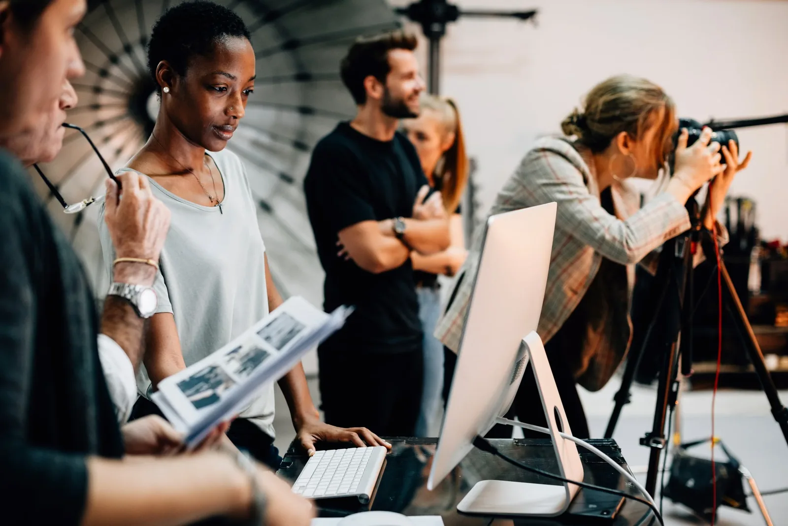 Production professionals collaborating behind screens